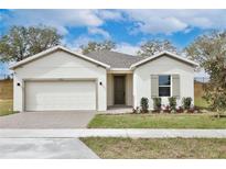 Charming single-story home with a brick driveway, well-manicured lawn, and neutral-toned facade at 1193 Stratton Ave, Groveland, FL 34736