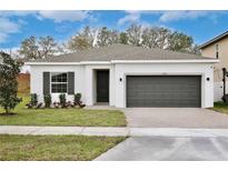 Charming single-story home featuring a two-car garage and well-manicured lawn at 1197 Stratton Ave, Groveland, FL 34736