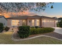 Charming home featuring a well manicured front yard, beautiful landscaping, and a two-car garage at 1537 Eastover Ter, The Villages, FL 32162