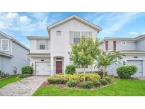 Charming two-story home with a well-manicured lawn and colorful landscaping at 1614 Moon Valley Dr, Champions Gate, FL 33896