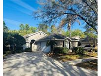 Charming single-story home features a well-manicured lawn, mature landscaping, and an attached two-car garage at 1661 Stafford Springs Blvd, Mount Dora, FL 32757