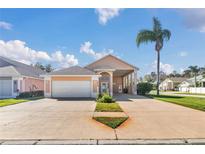 Charming single Gathering home boasting a two-car garage, long driveway, and desert landscaping at 16628 Citrus Pkwy, Clermont, FL 34714