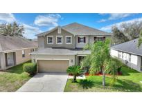 Inviting two-story home featuring a well-manicured lawn and a two-car garage at 201 Andover Dr, Davenport, FL 33897