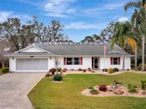 Charming single-story home with a well-manicured lawn and beautiful landscaping at 27003 Racquet Cir, Leesburg, FL 34748