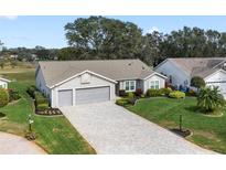 Charming single-story home boasts a two-car garage and a beautifully landscaped front yard at 4826 Summerbridge Cir, Leesburg, FL 34748