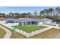 Charming single-story home featuring a well-manicured lawn and white picket fence at 54 Pecan Pass, Ocala, FL 34472