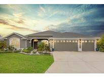 Beautifully landscaped home featuring a three car garage and neutral paint at 674 Waterman Way, The Villages, FL 32163