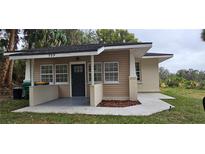 Charming single-story home with a covered front porch, manicured lawn, and craftsman style at 709 S Highland St, Mount Dora, FL 32757