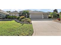 Charming single-story home with well-manicured lawn and a spacious driveway leading to a two-car garage at 1473 Honea Path, The Villages, FL 32162