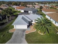 An aerial view of a charming single Gathering home with a well maintained lawn, driveway and attached two-car garage at 17490 Se 110Th Ter, Summerfield, FL 34491