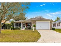 Charming single-story home featuring a well-manicured lawn and an attached two-car garage at 2136 Kerwood Loop, The Villages, FL 32162