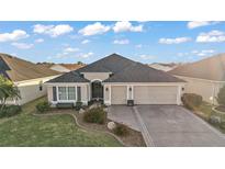 Inviting single Gathering home with a well-maintained lawn and attached two car garage at 2212 Bachman Path, The Villages, FL 32162