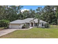 Charming single-story home featuring a well-manicured lawn, attached two-car garage, and a welcoming front porch at 2541 Lake Griffin Rd, Lady Lake, FL 32159
