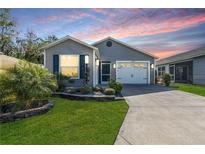 Charming single-story home featuring a well-manicured lawn and a two-car garage at 3390 Melissa Ln, The Villages, FL 32163