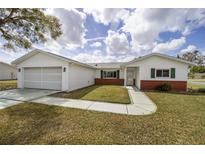 Charming single-story home featuring a well-maintained lawn and attached one-car garage at 17834 Se 105Th Ave, Summerfield, FL 34491