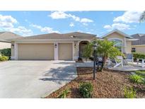 Charming single-story home featuring a three-car garage, a landscaped front yard and a welcoming front porch at 2279 Lowell Ter, The Villages, FL 32162