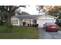 Charming single-story home with well-maintained lawn, neat shrubs, and attached garage at 25212 Clifford Hl, Leesburg, FL 34748