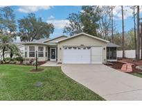 Charming single-story home featuring well-maintained landscaping, light siding, and a two-car garage at 32222 Summertree Circle, Leesburg, FL 34748