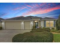 Charming single-story home featuring a well-maintained front yard, two-car garage, and inviting entrance at 3262 Dalkeith Ter, The Villages, FL 32163