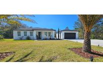Charming single-story home featuring a well-manicured lawn and separate garage at 42329 Chinaberry St, Eustis, FL 32736