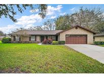 Charming brick home with a well-manicured front yard and a two car garage at 10122 Canterbury Dr, Leesburg, FL 34788