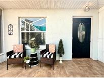 Charming front porch features stylish seating, plants, and tasteful decor for a welcoming entrance at 1131 Apple Ter, Leesburg, FL 34748