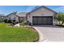 Charming single-story home with lush lawn, neat landscaping, and a two-car garage at 12199 Se 175Th Loop, Summerfield, FL 34491