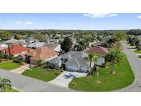 An elevated view of this home shows mature landscaping and a three car garage at 1367 Honea Path, The Villages, FL 32162