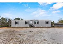 New construction home with gray siding, black shutters, and small front porch at 147 Woodstork Way, Frostproof, FL 33843