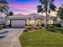 Charming single-story home featuring a well-manicured lawn and a two-car garage at 17694 Se 88Th Covington Cir, The Villages, FL 32162