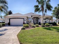 Charming single-story home with a well-manicured lawn and a driveway leading to a spacious two-car garage at 17694 Se 88Th Covington Cir, The Villages, FL 32162