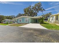 Charming single-story home featuring a carport, freshly painted exterior, and a well-maintained front yard at 2 Heather Ln, Fruitland Park, FL 34731