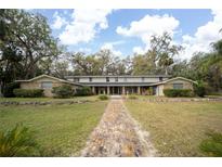 Well-maintained home with a brick facade, manicured landscaping, and a welcoming pathway leading to the entrance at 2930 Cr 416N, Lake Panasoffkee, FL 33538