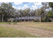 Two-story home featuring a symmetrical design, brick accents, and lush landscaping at 2930 Cr 416N, Lake Panasoffkee, FL 33538