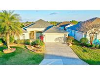 Charming single-story home with a well-manicured lawn, mature landscaping, and a two-car garage at 3144 Mayflower Loop, The Villages, FL 32163