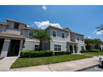 Charming two-story townhome with lush landscaping, tropical palms, and neutral gray paint at 4836 Romeo Cir, Kissimmee, FL 34746