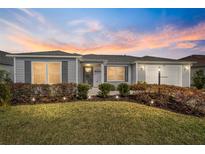 Charming single-story home with manicured lawn, landscape lighting, and attached garage at 781 Nancy Dr, The Villages, FL 32163