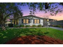 Charming home at dusk featuring lush lawn, tidy landscaping, and inviting screened entrance at 915 Oleander St, Lady Lake, FL 32159