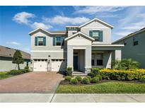 Charming two-story home featuring a three-car garage, brick driveway, and professionally landscaped front yard at 9729 Lost Creek Dr, Winter Garden, FL 34787