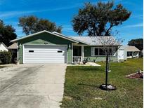 Charming single-story home with a well-maintained lawn and attached garage at 1108 Ben Hope Dr, Leesburg, FL 34788