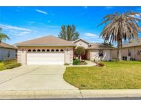 Charming single-story home featuring an attached two-car garage and a well-manicured lawn with mature landscaping at 12225 Se 173Rd Pl, Summerfield,, FL 34491