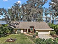 Charming single-story home featuring well-maintained landscaping, mature trees, and attached two car garage at 1322 Howard Rd, Leesburg, FL 34748