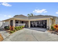 Charming home featuring a beige exterior, well-kept landscaping, screened in porch, and oversized garage at 16801 Se 74 Soulliere Ave, The Villages, FL 32162