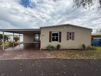 Charming single-story home featuring a covered carport and view of the lake at 22 Big Tree Dr, Fruitland Park, FL 34731