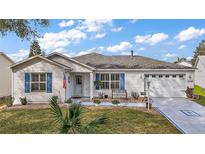 Charming single-story home featuring a well-manicured lawn and inviting curb appeal with a white picket fence at 273 Pomaria Pl, The Villages, FL 32162