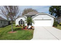 Charming single-story home with well-manicured lawn, mature trees, and attached two-car garage at 3720 Eversholt St, Clermont, FL 34711