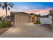 Charming single Gathering home with a two-car garage, mature landscaping and beautiful evening sky at 483 Cammarano Pl, The Villages, FL 32162