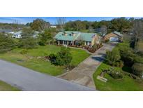 Charming home featuring a long driveway, well-manicured lawn and mature landscaping at 4940 County Road 134B, Wildwood, FL 34785