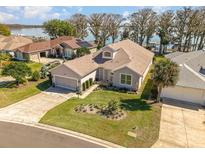 Inviting single-story home with a well-manicured lawn and an attached two-car garage near the lake at 6342 Sailboat Ave, Tavares, FL 32778