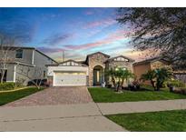 Charming single-story home featuring stone accents, a two-car garage, and a well-manicured front yard at 9188 Chandler Dr, Groveland, FL 34736